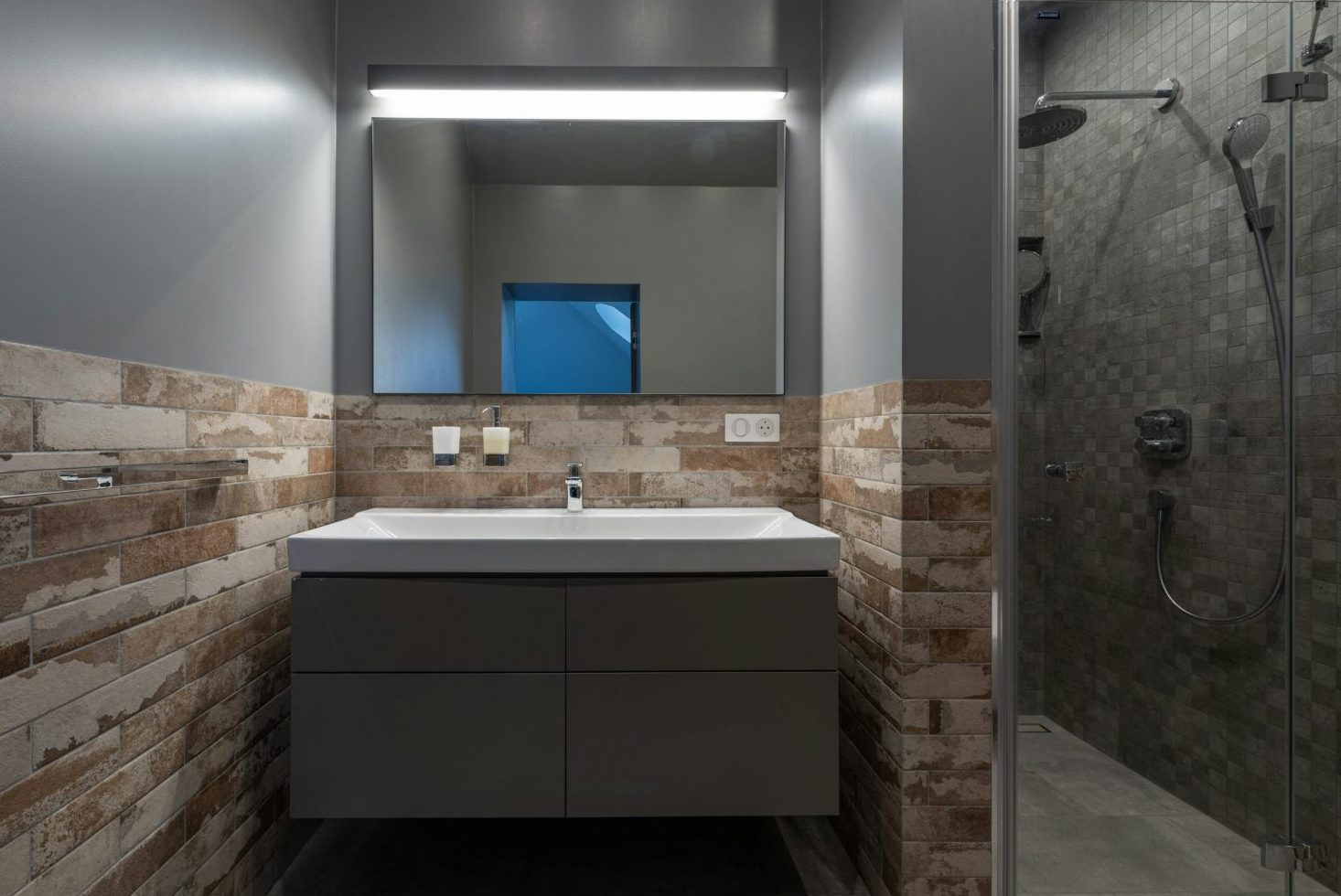 Contemporary bathroom with a glass shower and illuminated mirror.